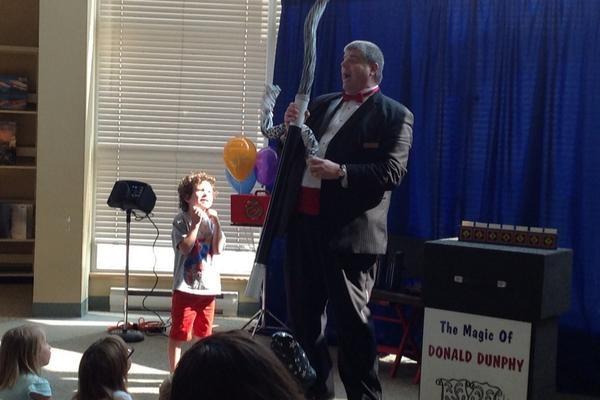 Donald is surprised by spring worms during his magic show for an audience at a library.